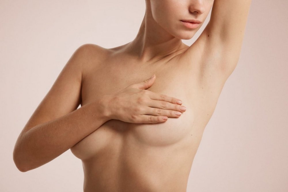Closeup-cropped-portrait-young-woman-with-breast-pain-touching-chest-colored-isolated-on-background.jpg