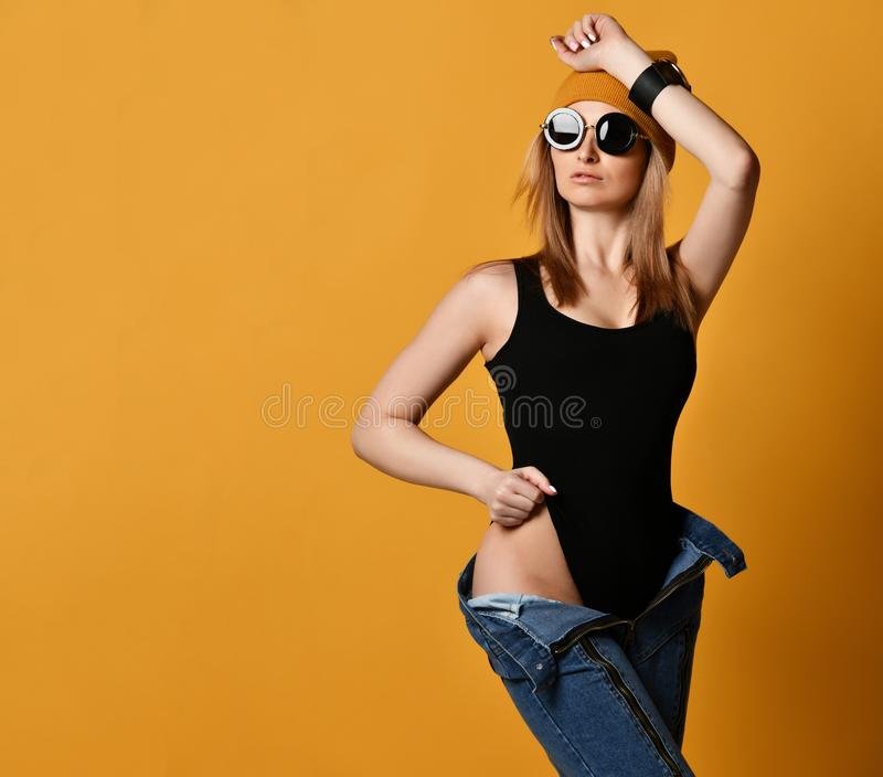 young-fashion-woman-wearing-unbuttoned-jeans-legs-black-sexy-swimsuit-yellow-background-154549106.jpg